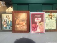 Four framed portraits including family, praying hands, First Communion card, and religious prayer with Jesus image