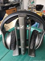 Sennheiser HDR 160 headphones on base station showing front and side views with ear pads and headband visible.