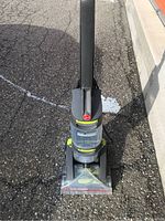Hoover Dual Power carpet cleaner upright view showing front with transparent cleaner head and handle.
