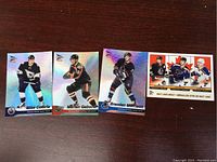 Four McDonald's Upper Deck NHL hockey cards displayed on a wooden surface.