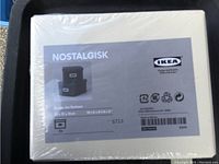 Photo showing the front label of two IKEA Nostalgisk storage boxes sealed in white with product information and dimensions.