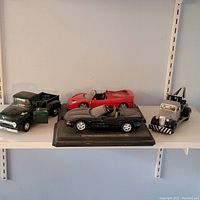 Full set of four diecast model cars arranged on a shelf showing varying styles and colors
