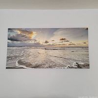 Front view of the canvas photo showing the full ocean sunset scene on a stretcher frame hung on the wall.