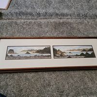 Full view of the diptych in its frame showing two connected coastal landscapes with rocks and trees under misty skies.