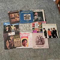 Photo showing 10 vinyl record albums laid out on carpet. Covers include Jefferson Airplane, Pretenders, Sam Cooke, The Coasters among others.
