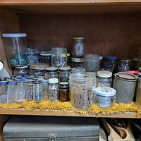 Shelf with multiple glass jars containing screws, nails, and small hardware items
