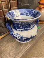 Front angled view showing full pot, blue patterns and one animal-shaped handle
