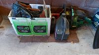 Overview of chainsaw, jerry can, oils and hearing protection on floor
