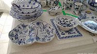 Blue Danube divided dish with handle, Blue Danube serving plates stacked, trivet, and other ceramic dishes on display