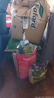A large beige bag of Fafard peat moss with price tag, green bag behind and two smaller bags of Schultz Vermiculite and Planting Mix in front.