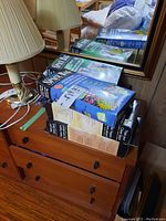 Five boxed space saver vacuum-seal storage bags arranged on wooden surface beside lamp and mirror.