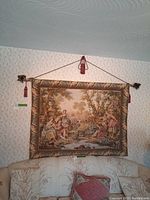 Full view of tapestry wall hanging on rod displayed above a couch, showing overall size and design.