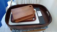 Overall view of the lot showing large dark wooden tray, smaller trays and multiple cutting boards inside it.
