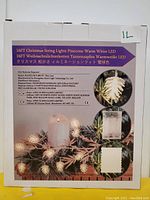 Photo of the box for 16 ft pinecone shaped Christmas string lights with warm white LED bulbs, showing brand and product details.