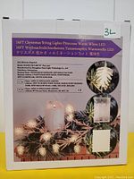 Box packaging showing product details including brand AiP, model SL-16M-50, battery requirement (3 AA), warm white LED pinecone shaped string lights, 16 feet length