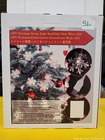 Photo of retail box showing 19-foot Christmas string light with clear white snowflake LED bulbs and USB power.
