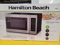 Photo of the Hamilton Beach microwave oven box showing product image and specifications.