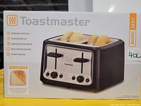 Boxed Toastmaster 4-slice toaster showing brand, model features and image of the product with bread slices in slots
