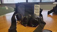 Front view of Panasonic Lumix camera and black carrying bag with MaxSold lot tag.