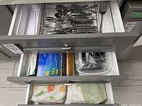 Second drawer with boxes of plastic wrap and foil, and kitchen containers