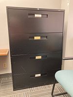 Frontal view showing four drawers with handles and label holders, minor scratches visible on the surface.