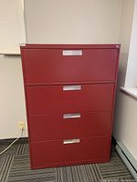 Front view of red Lincora filing cabinet with four drawers and silver handle pulls.