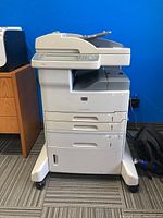 Front view of HP LaserJet M5035 MFP showing overall unit and three paper trays