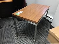 Side table metal frame legs and laminate top surface from a side view showing table height and design.
