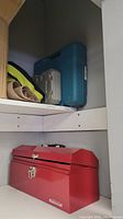 Red Mastercraft tool box and cases with drills stored on shelving