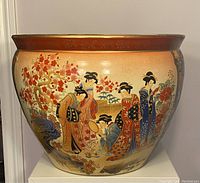 Front side showing geishas and floral designs on porcelain planter