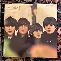 Front cover of The Beatles For Sale LP showing four band members in close-up against blurred background