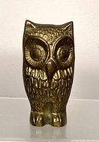 Front view of brass owl figurine showing detailed eyes and feather pattern