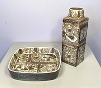 Photo showing side view of brown and white vintage fajance dish and tall rectangular Baca vase with detailed textured patterns.