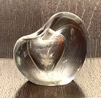 Front angle of clear glass sculpture showing internal heart form and smooth curving shape.