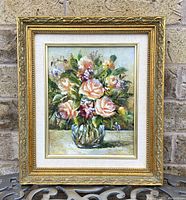 Full view of the framed oil painting showing the floral bouquet and ornate gold frame.