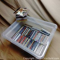 Plastic bin filled with a well-organized collection of music CDs.