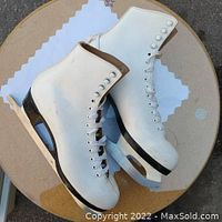 Top view of the Bauer figure ice skates, showing white leather boots and black soles with silver blades.
