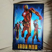 Full view of the vibrant blue Iron Man metal poster with multiple Iron Man images and title