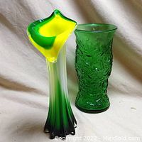 Front view of two green decorative vases, showing shape, color and texture details