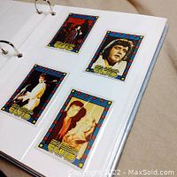 Photo showing four Elvis Presley trading cards in a ring binder album on a white page with clear sleeves.
