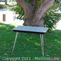 Full view of the vintage rectangular Arborite table with chrome legs outdoors under a tree