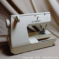 Side view of white Singer sewing machine showing main body and sewing needle area