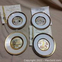 Four Chokin plates displayed including three with certificates of authenticity, showing detailed gold decorations and embossed designs.