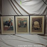 Photo showing all three framed vintage car advertisements side by side, highlighting their size and framing.