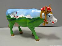 Side view showing painted landscape and floral headpiece on the cow figurine