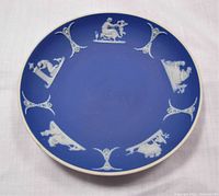 Top view showing blue jasperware dish with white classical figure relief decorations around edge.