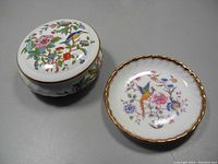 View of the top of the lidded vanity dish and small shallow dish showing colorful bird and floral motifs with gold trim.