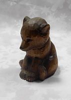 Front view of the hand carved wooden bear cub showing detailed facial features and paw carving.
