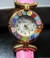 Close-up of the Venetiae watch face showing colorful Murano millefiori glass bezel and gold-tone case.