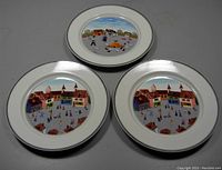 Three Villeroy & Boch Naif decorative plates showing village scenes on a grey surface.